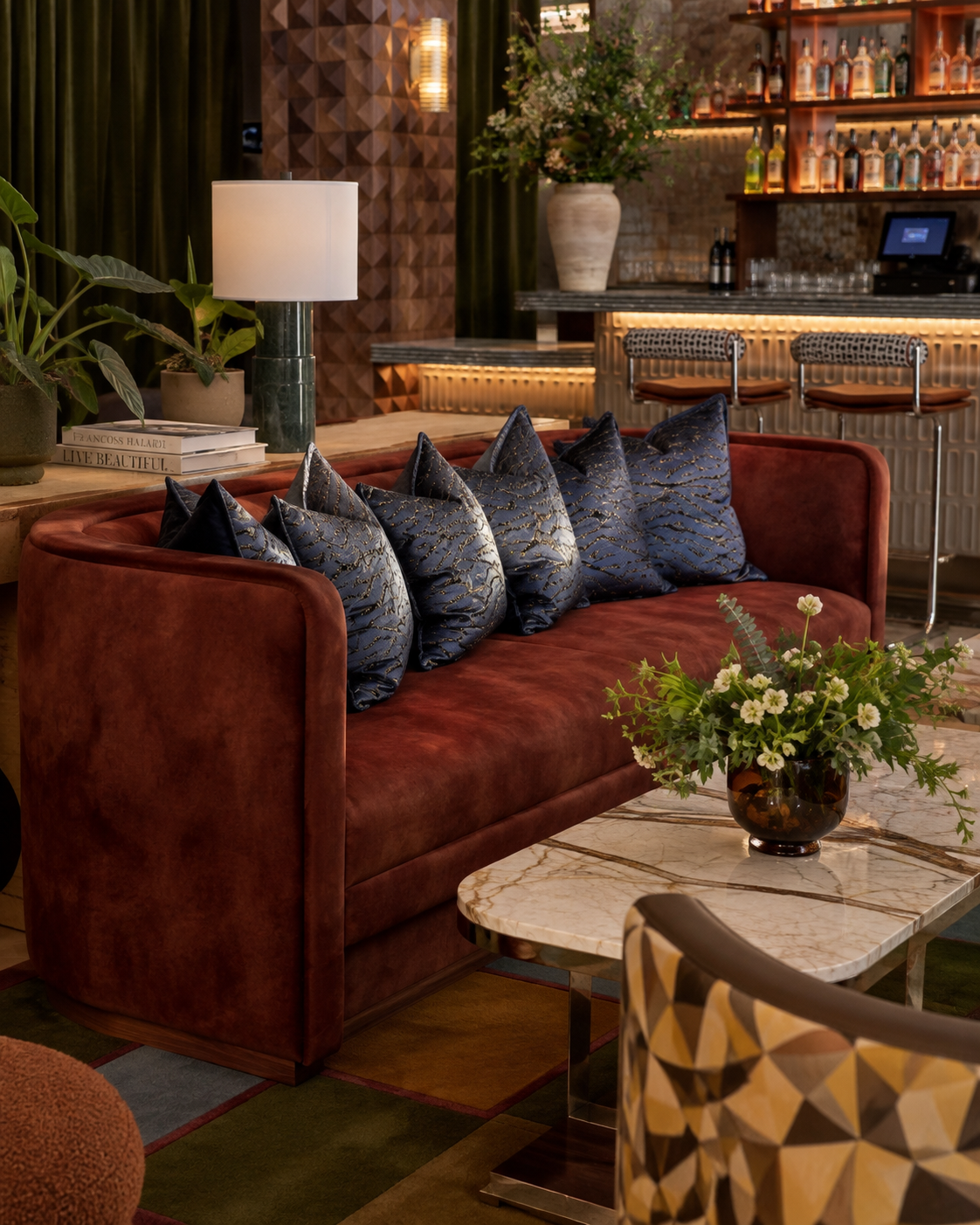 Velvet sofa and marble table in a warmly lit lounge
